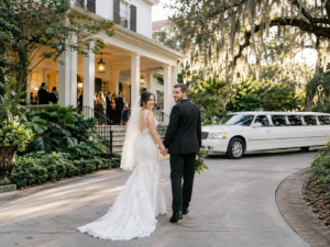 Bride and groom arriving at a Gainesville wedding venue with white limousine